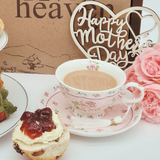 Fruit & Plain Scone Cream Tea, close up of scones with cream and jam next to cup of tea and flowers.