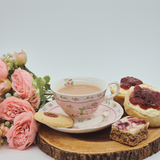 Afternoon cream tea close up showing, scones, cream, jam, cup of tea, flapjack and shortbread.